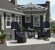 Outdoor patio setup with two blue Krahn Adirondack Gliders, a striped Basil Bangs umbrella, a Fatboy ottoman, and a Krahn End table on a deck.