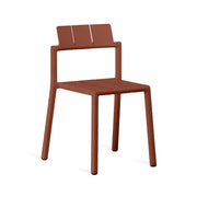 Yard chair by TOOU Design in rusty red, showcasing its sleek geometric design, durable polypropylene material, and stackable functionality.