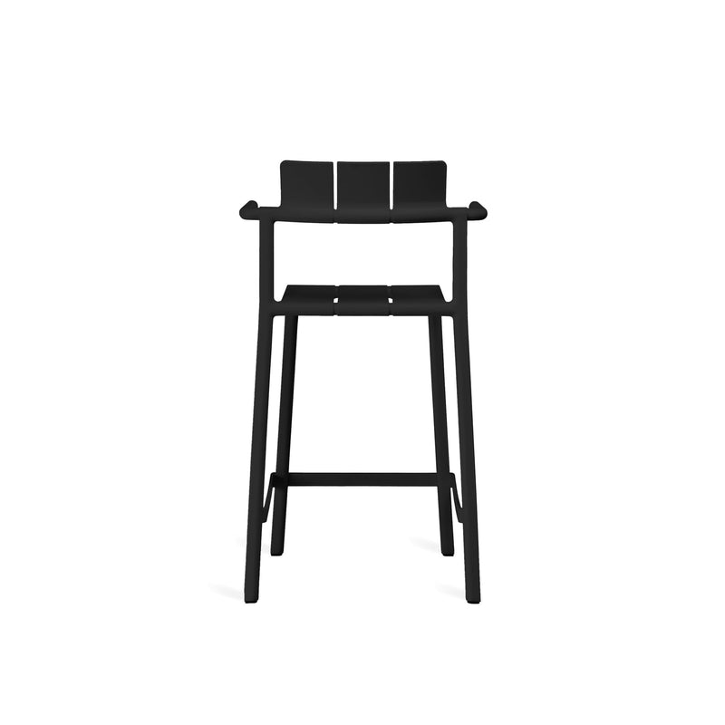 Yard counter stool with arms by TOOU Design in a cafe setup, highlighting its ergonomic design and practical stackable feature.