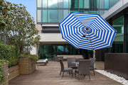 Frankford Cantilever Aurora 11 foot Octagon Umbrella with blue and white stripes in a outdoor patio setting. 