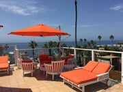 Frankford Cantilever Aurora 11 foot octagon umbrella in orange colour in an outdoor patio setting overlooking the water