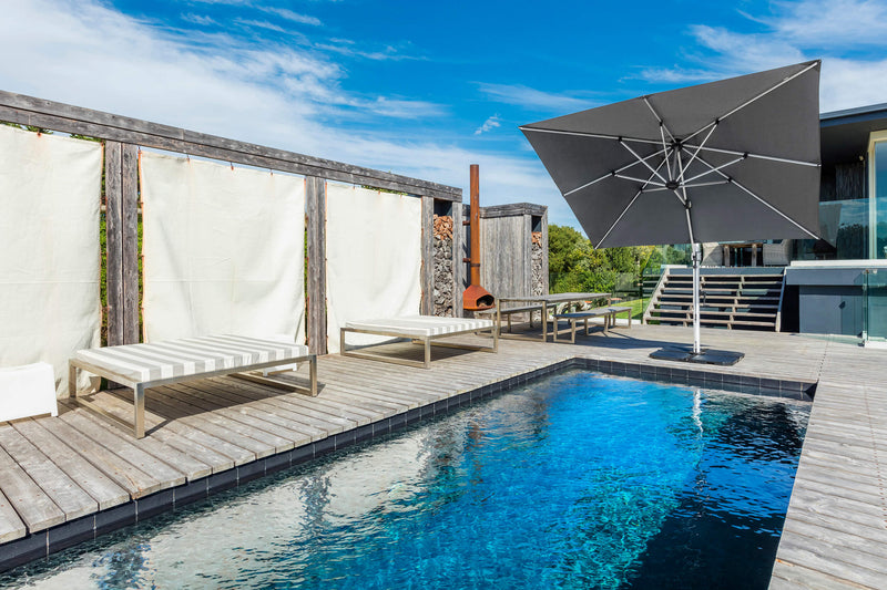 Frankford Cantilever Aurora 9 foot square umbrella in gray colour in a pool setting