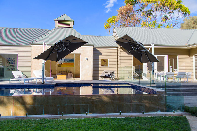 Frankford Cantilever Aurora 9 foot square umbrella in a backyard pool setting