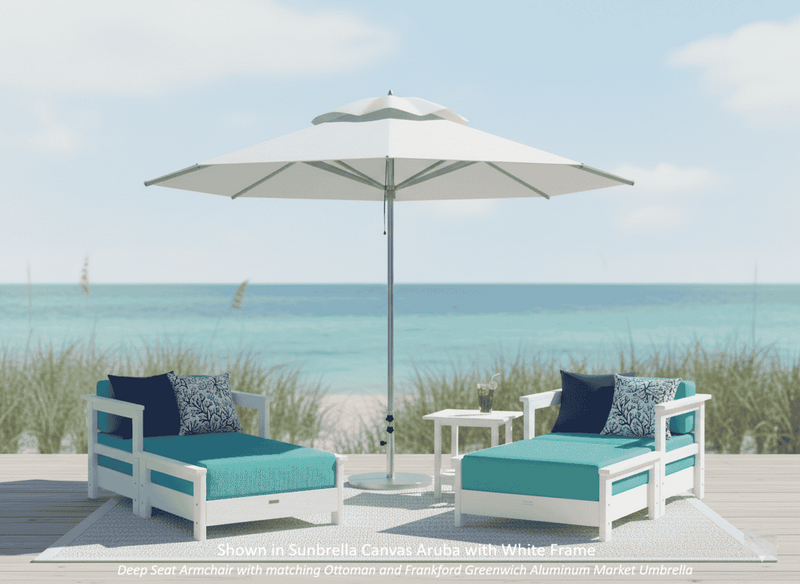 Krahn outdoor furniture patio set with two deep seat armchairs with matching ottoman, a krahn side table, and an frankford greenwich market umbrella on a beach.