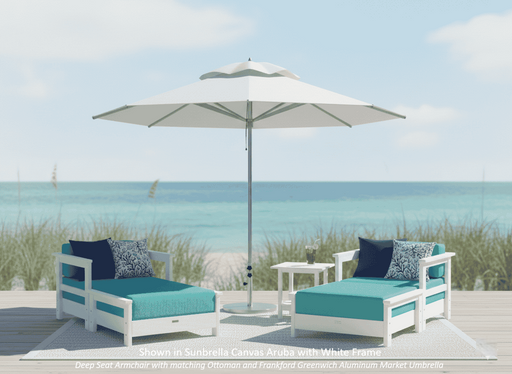 Krahn outdoor furniture patio set with two deep seat armchairs with matching ottoman, a krahn side table, and an frankford greenwich market umbrella on a beach.