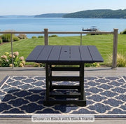 Krahn Dining Table in black on a deck with a view of the water in the background