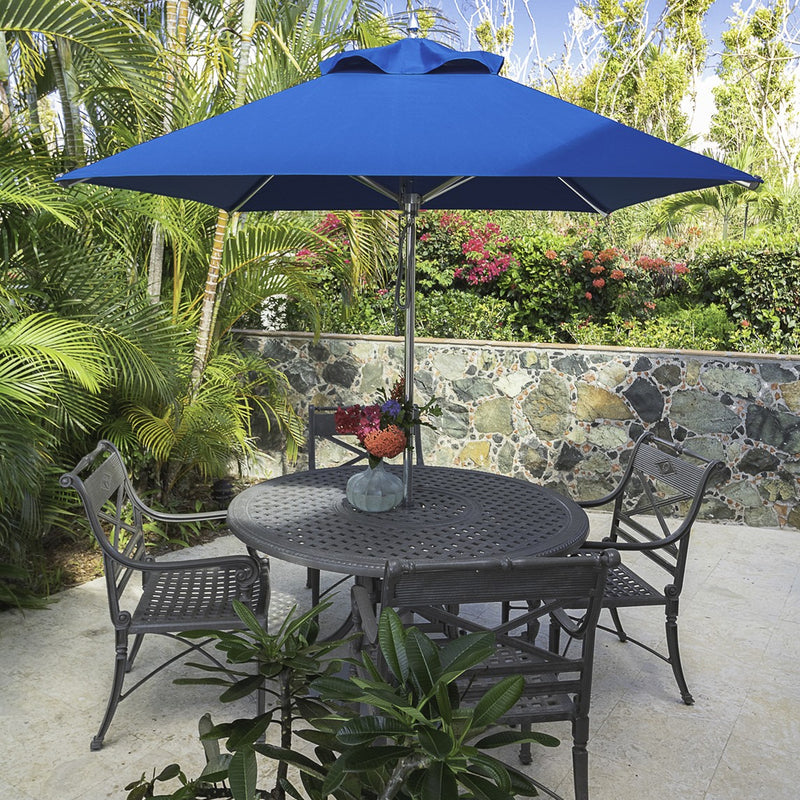 Frankford Greenwich 6.5' Square Pacific Blue Umbrella in a dining table on a patio