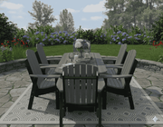 Krahn outdoor patio set with table and chairs on a stone patio with garden in the background