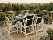 Krahn outdoor poly bistro table and chairs on a wooden deck overlooking a valley of trees