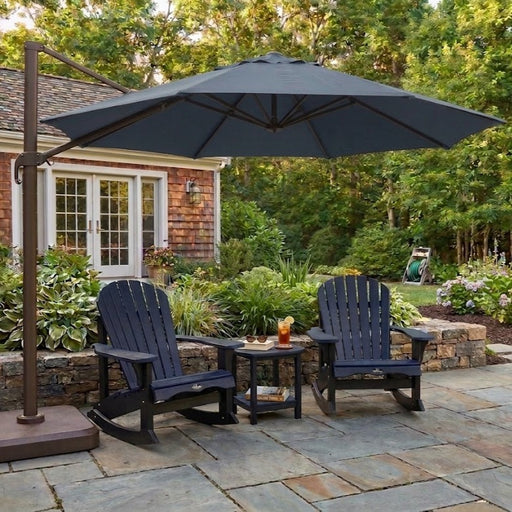 Two Navy Krahn Adirondack Rockers with a Krahn end table on a backyard patio with an umbrella
