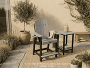 Krahn outdoor poly bistro chair with recycled plastic end table on a patio with plants and a lantern.