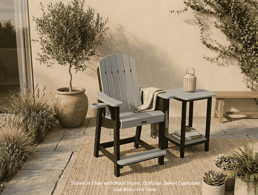 Krahn outdoor poly bistro chair with recycled plastic end table on a patio with plants and a lantern.