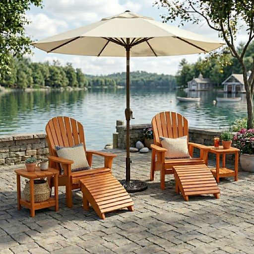 Two Tangerine Krahn Patio Deluxe Chairs with two end tables and an umbrella on a stone patio overlooking the water