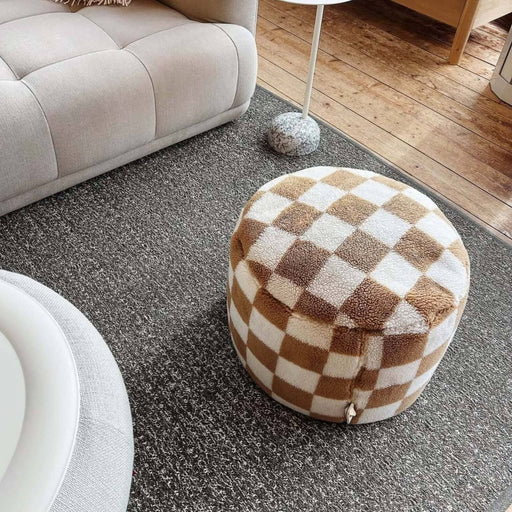 Soft indoor pouf with plush teddy fabric and a bold checkered design, filled in Canada.