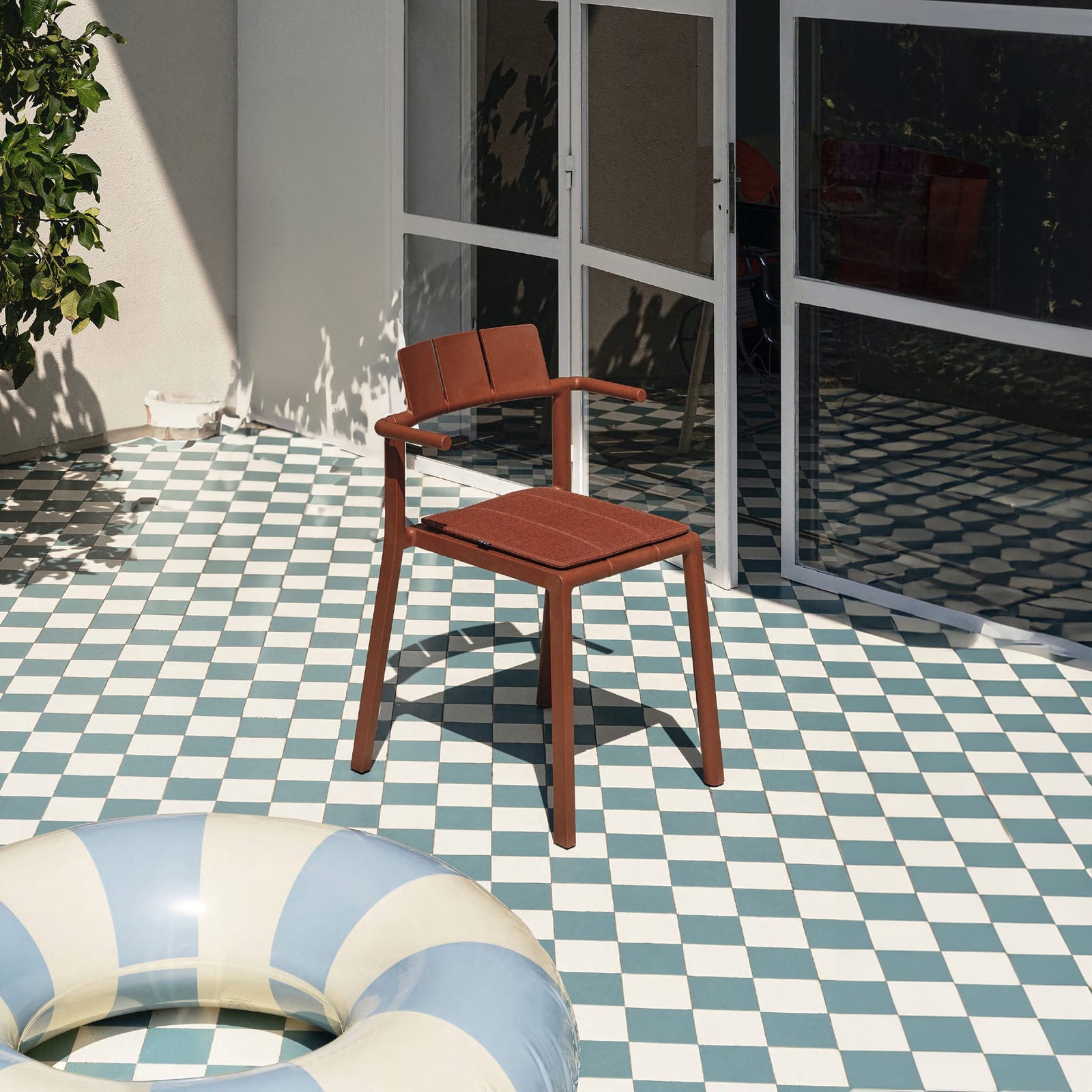 Yard armchair by TOOU Design on a contemporary patio, highlighting its comfortable ergonomic shape and robust polypropylene construction.